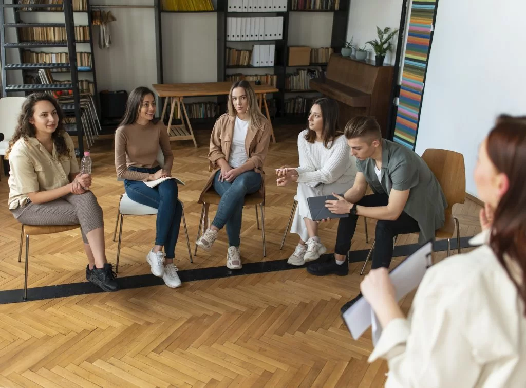 Close-up of people sitting in a circle during a group therapy session