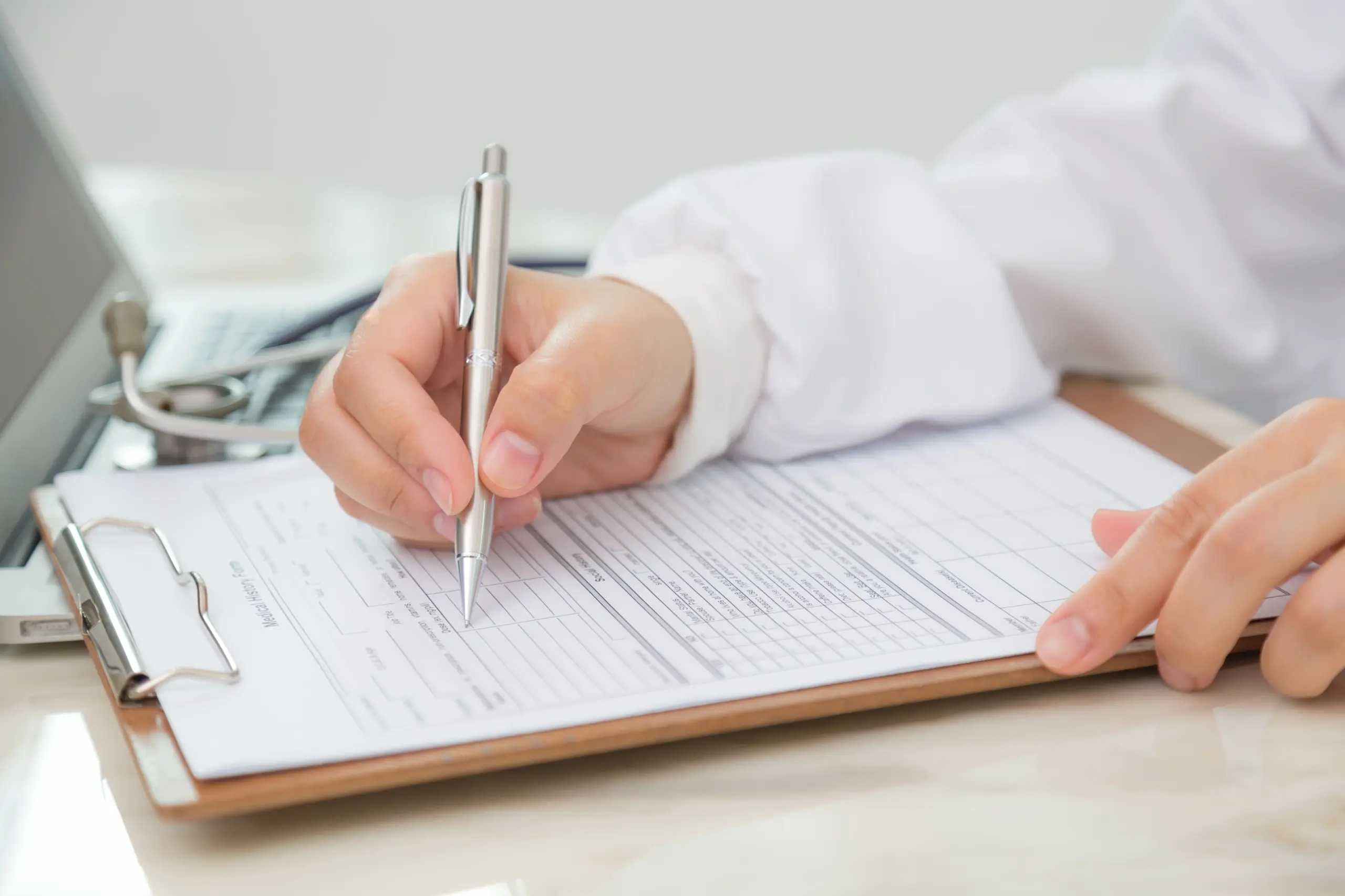 Prescriber writing a prescription for botulinum toxin after a face-to-face consultation
