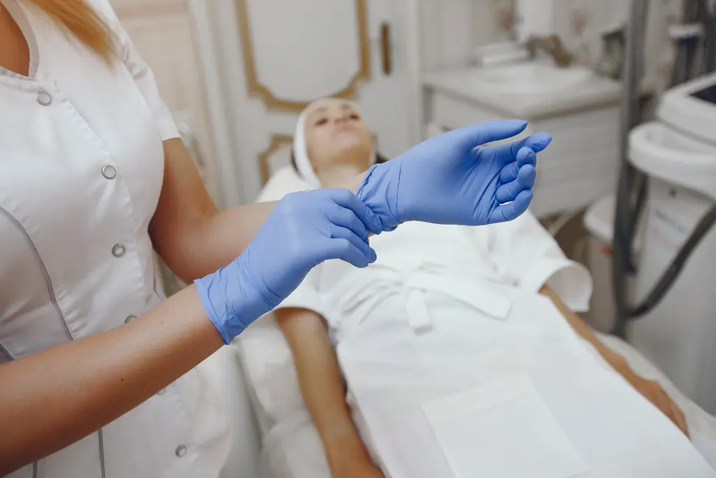 Clinician puts blue gloves on before working on patient