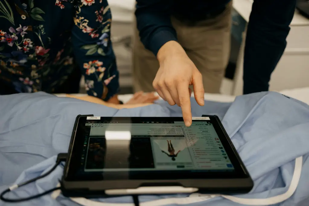 Two people looking at a patient portal on a tablet