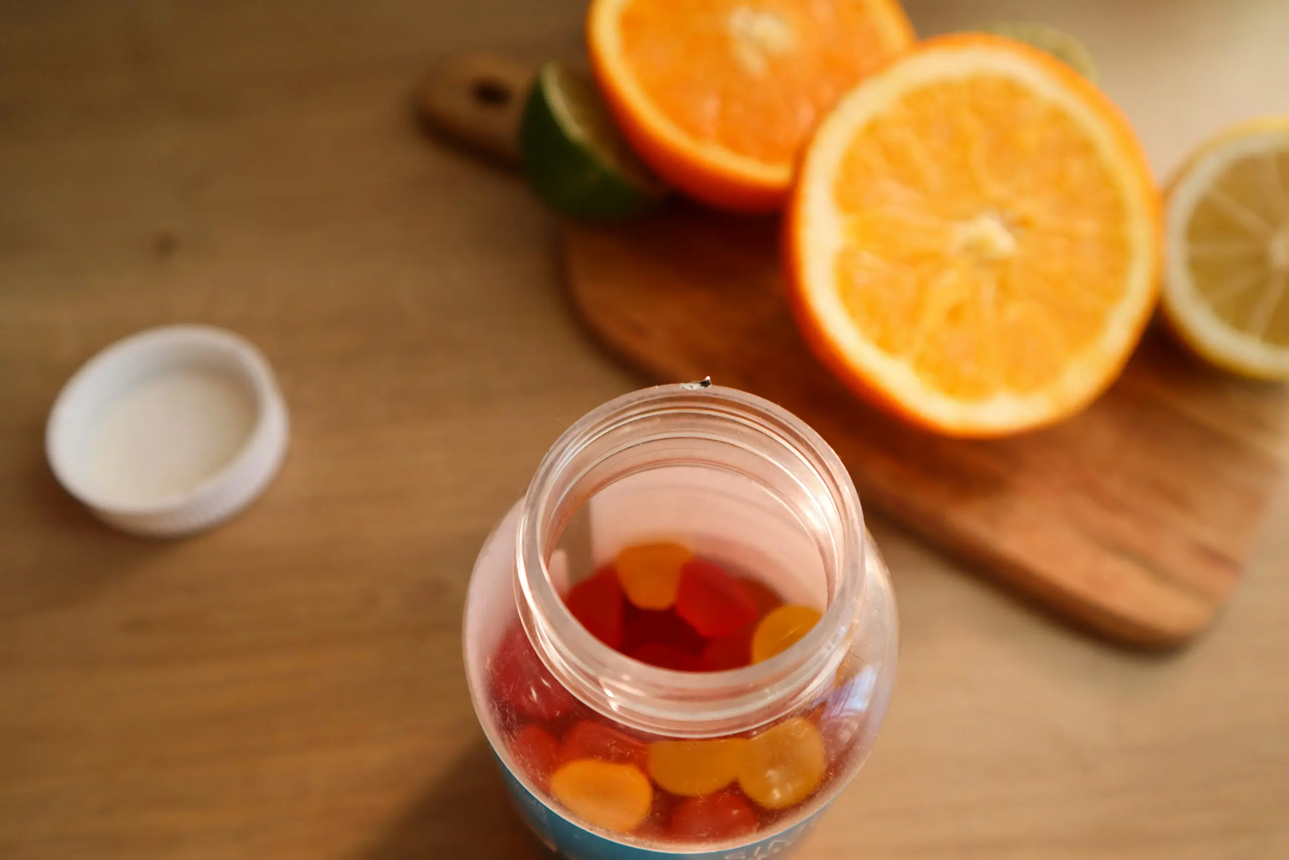 Oranges and vitamin D supplement capsules on a table