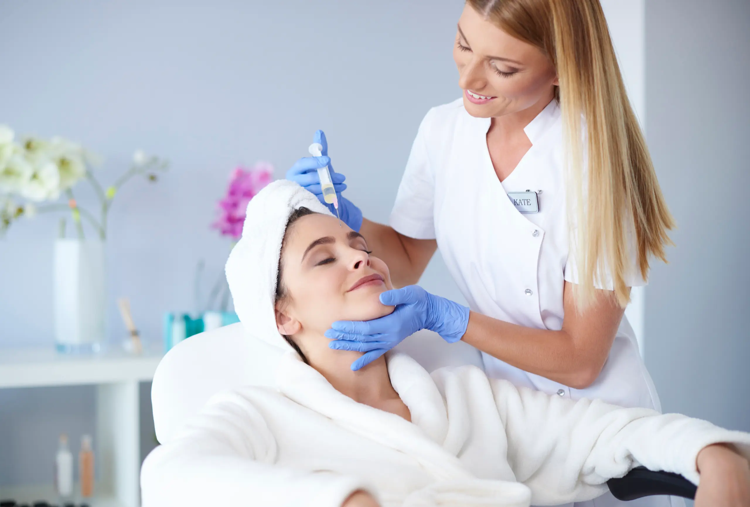 Aesthetic practitioner administering a botulinum toxin injection to a client in a UK clinic