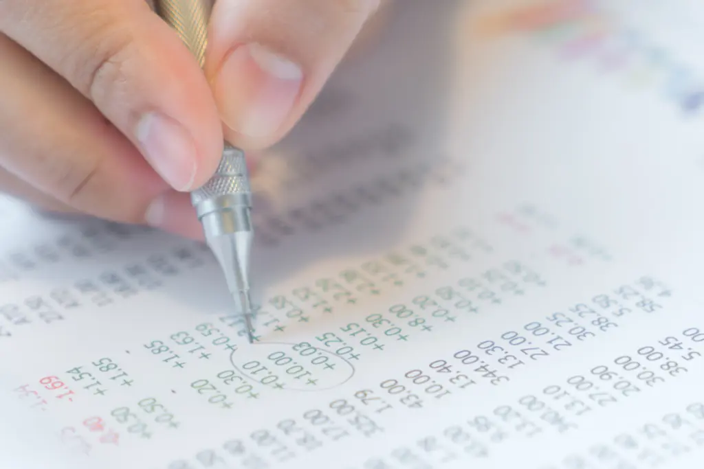 Hand write on various financial charts on the table.