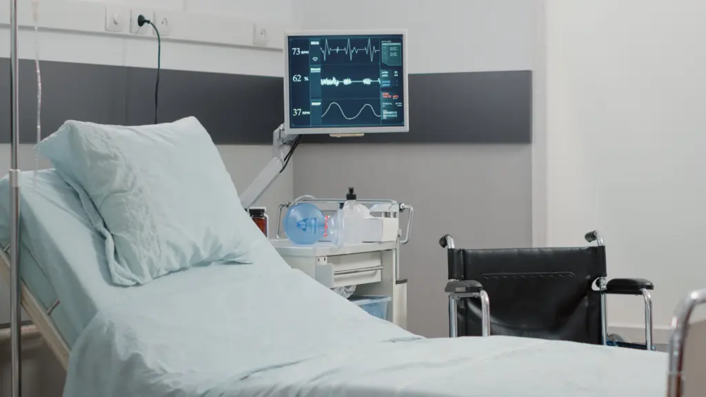 Empty hospital ward with heart rate monitor bed healthcare recovery nobody emergency room with medical equipment intensive care patient reanimation room with tools.
