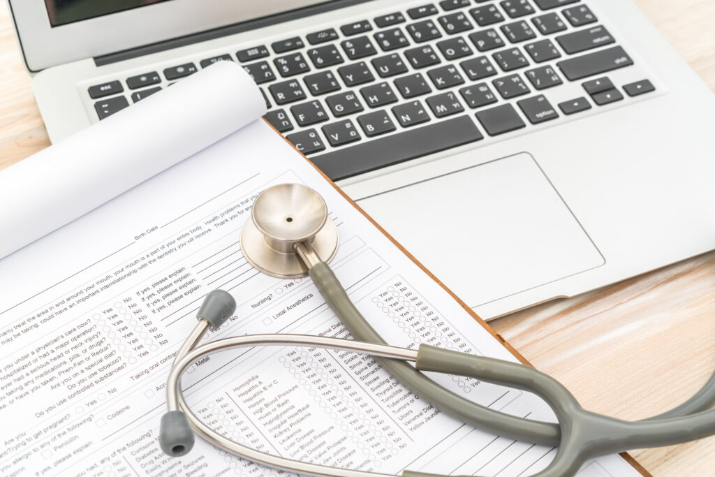 stethoscope and prescription on a laptop
